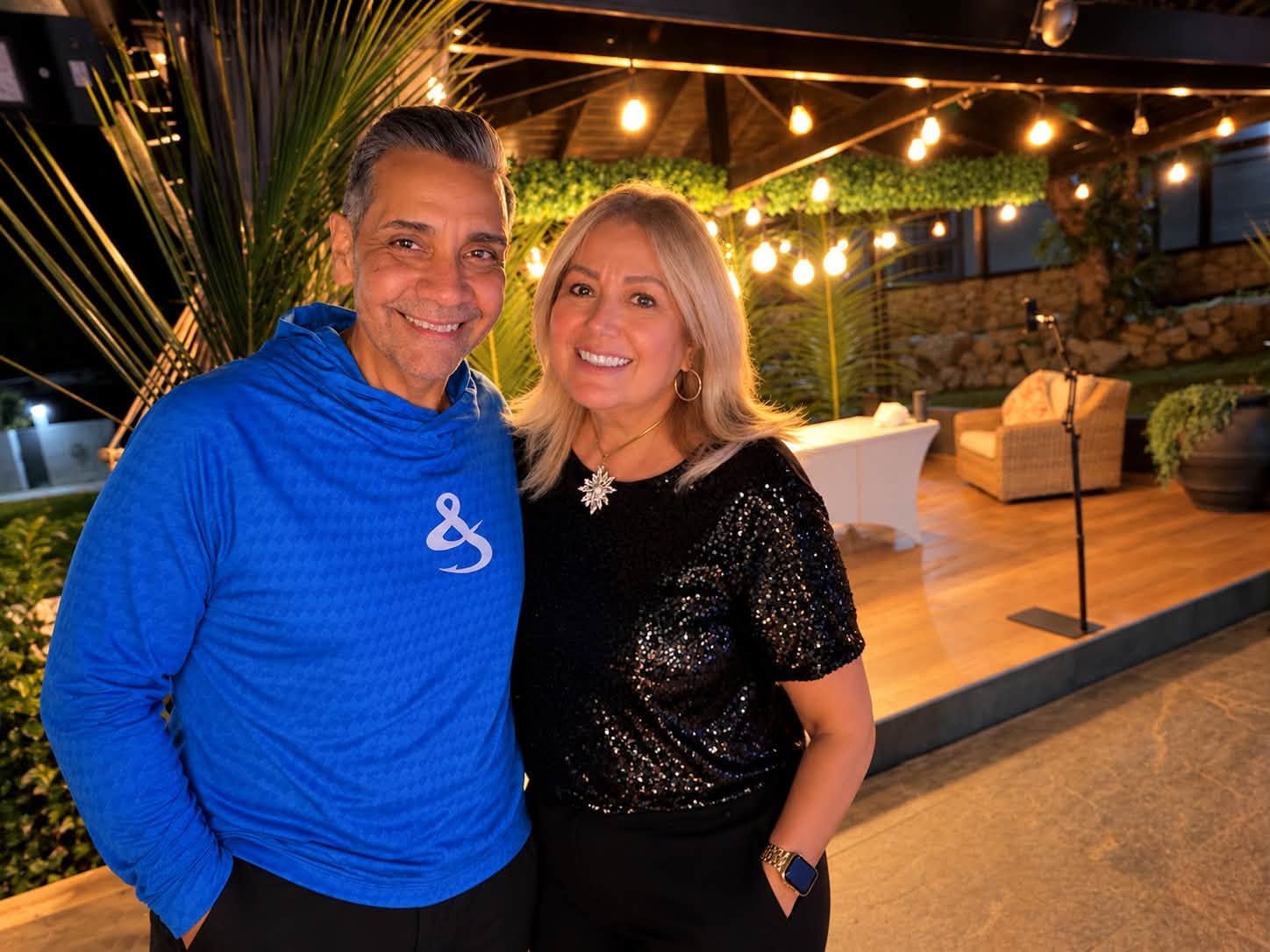 Pastores Walter y Maritza Agosto sonriendo juntos en una terraza iluminada